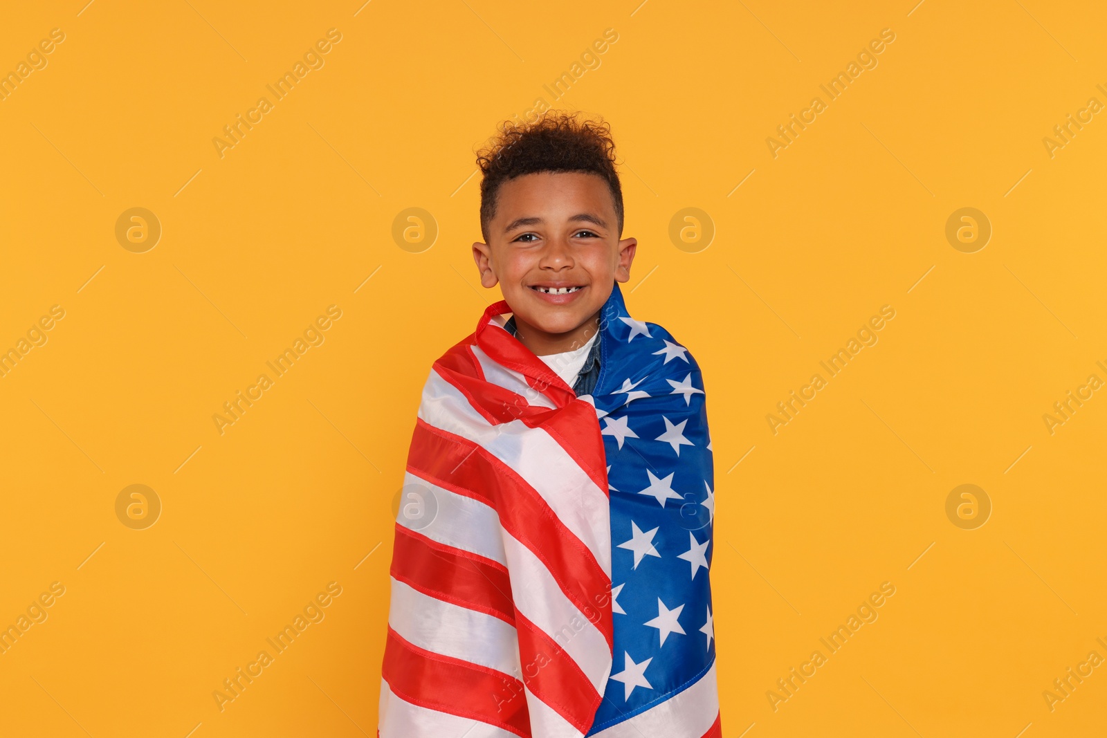 Photo of 4th of July - Independence Day of USA. Happy boy with American flag on yellow background