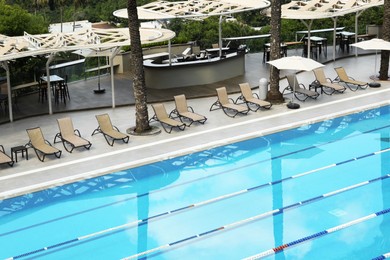 Empty sunbeds near outdoor swimming pool at resort