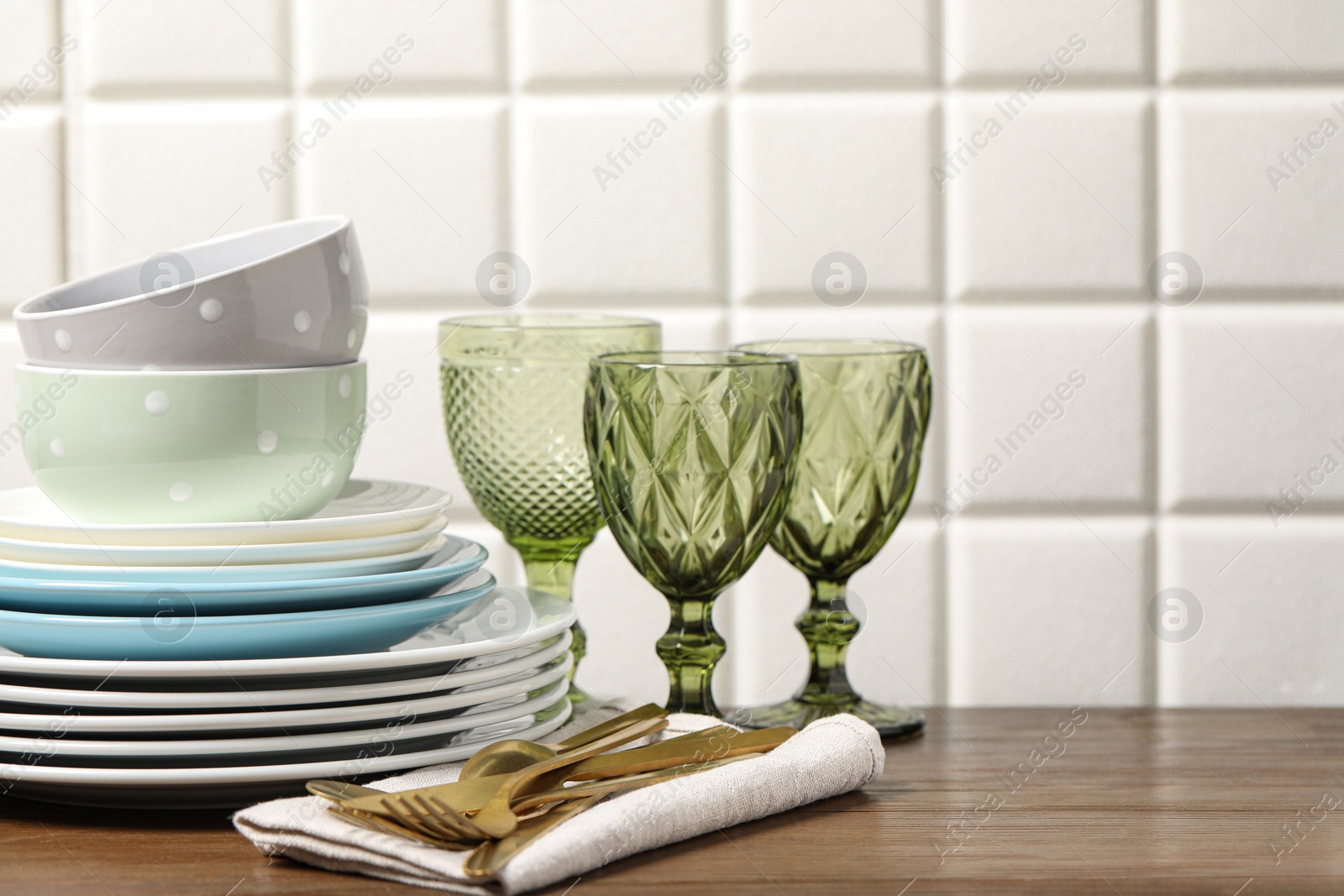 Photo of Beautiful ceramic dishware, glasses and cutlery on wooden table, space for text