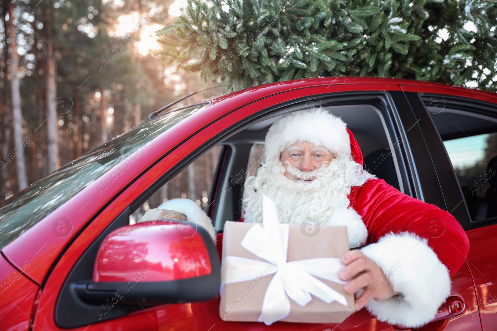 Photo of Authentic Santa Claus in car with gift box, view from outside