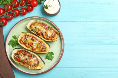 Photo of Flat lay composition with delicious stuffed zucchini on light blue wooden table. Space for text