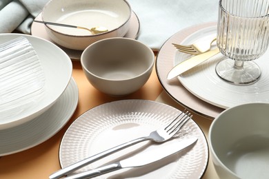 Clean plates, bowls, glass and cutlery on table