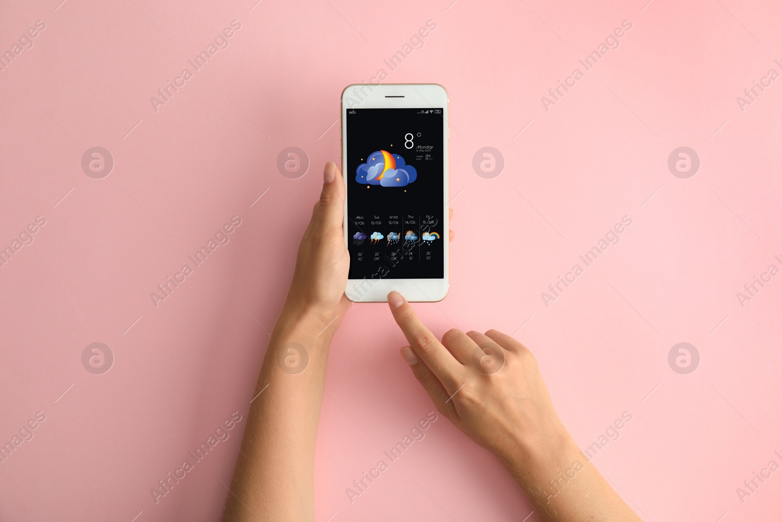 Image of Woman using weather forecast app on smartphone on pink background, top view