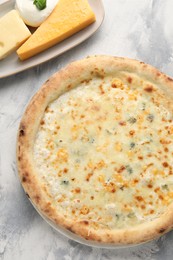 Delicious cheese pizza and different kinds of cheese on light grey textured table, flat lay