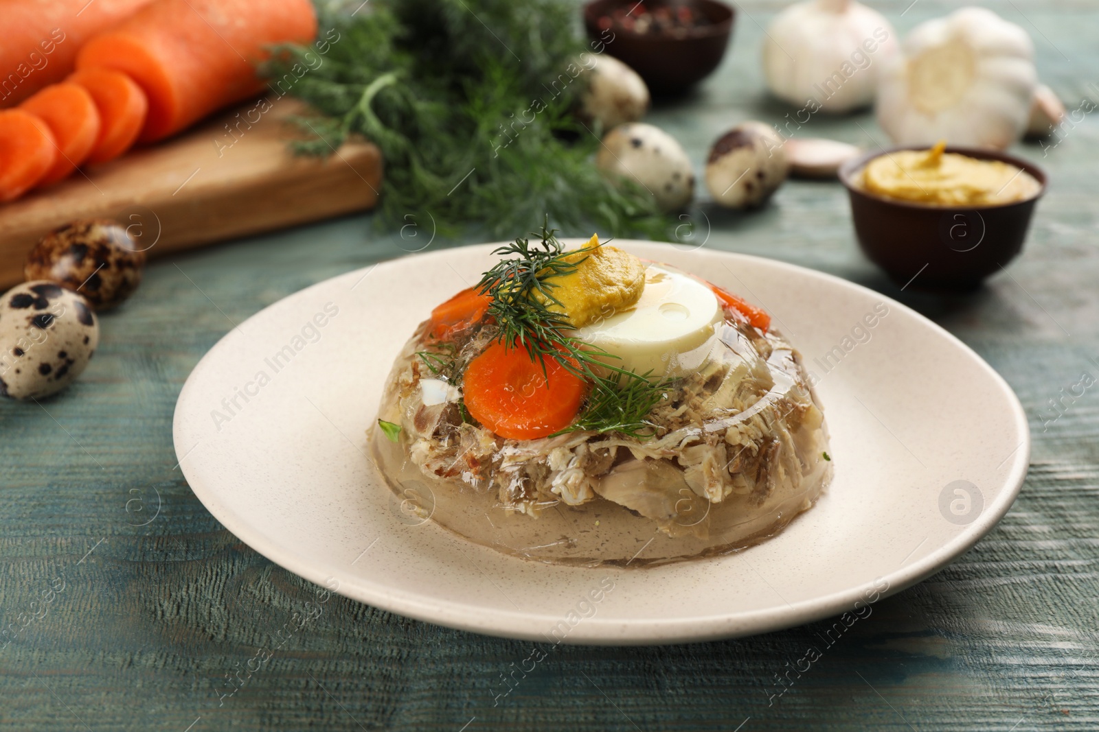 Photo of Plate with delicious aspic on light blue wooden table