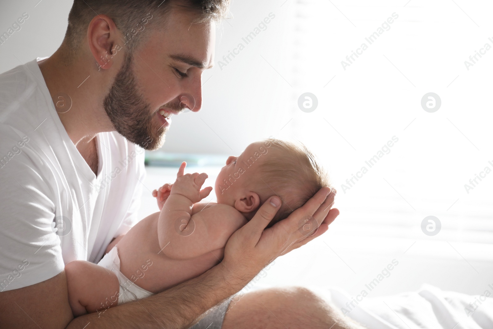 Photo of Father with his newborn son at home