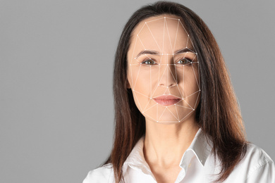 Image of Facial recognition system. Mature woman with biometric identification scanning grid on grey background