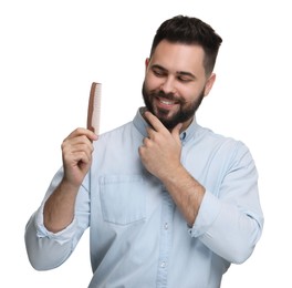 Handsome young man with mustache holding comb on white background