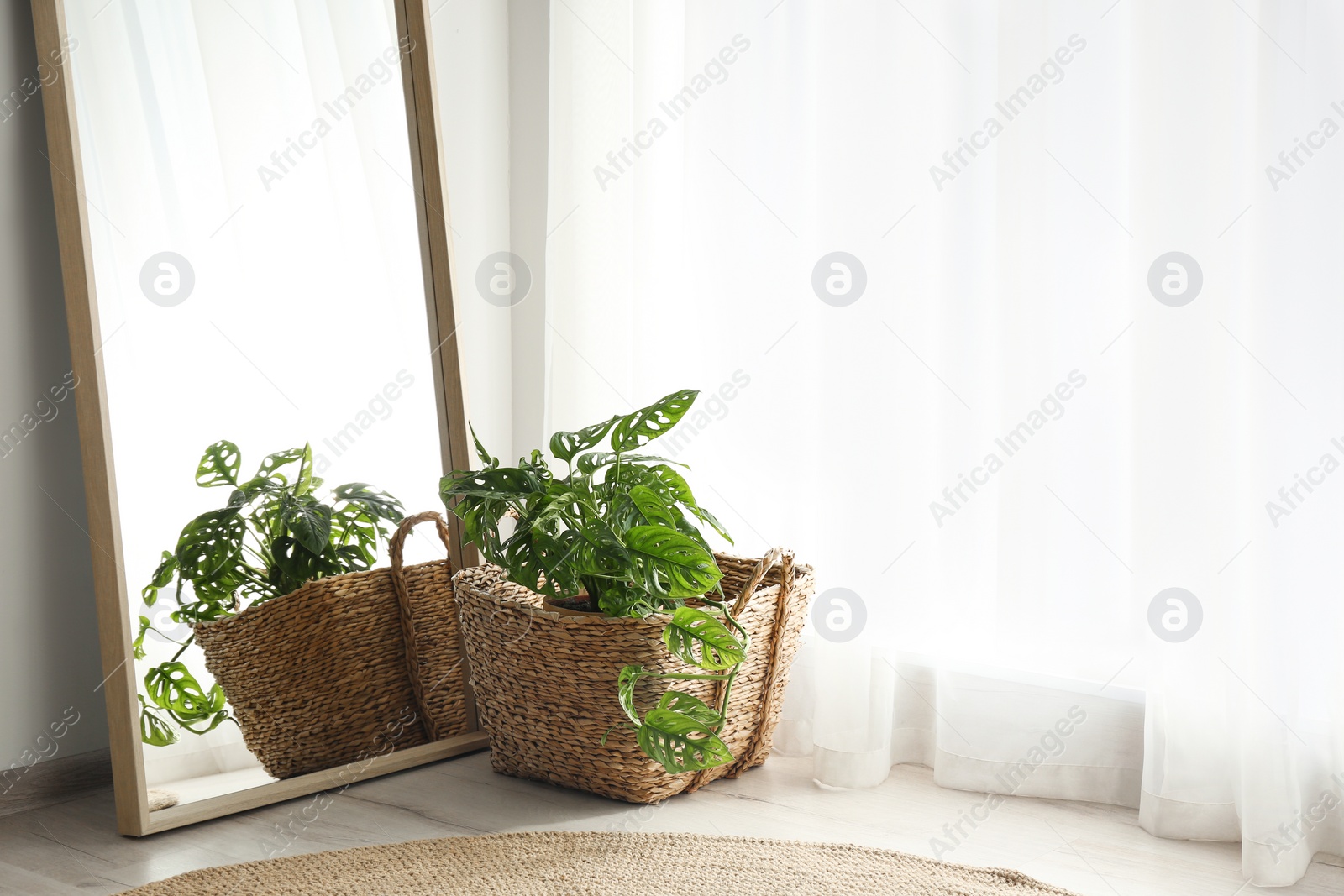 Photo of Large mirror with wooden frame near window in light room