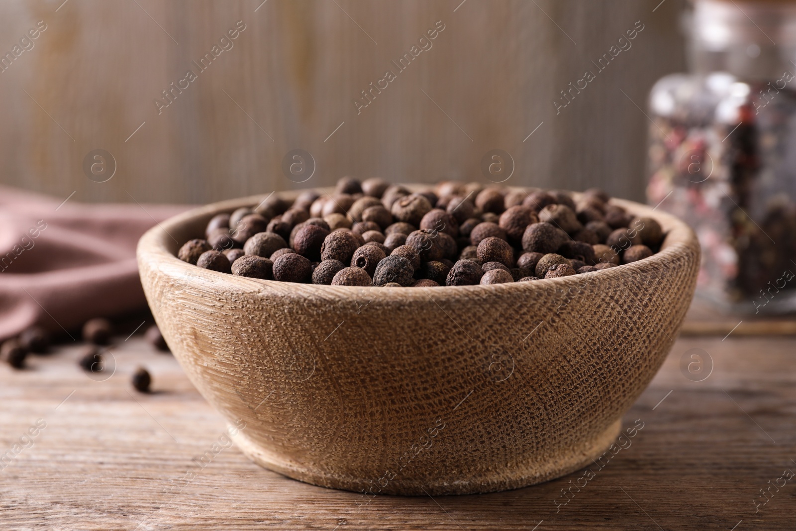 Photo of Peppercorns in bowl on wooden table, closeup