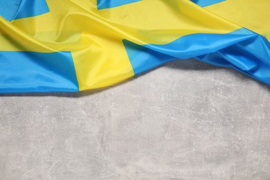 Flag of Sweden on light gray textured background, top view. Space for text