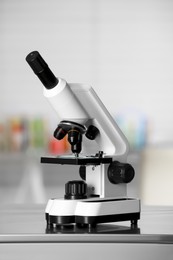 Modern medical microscope on metal table in laboratory