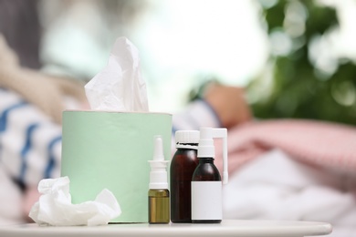 Cough remedies and box with tissues on table