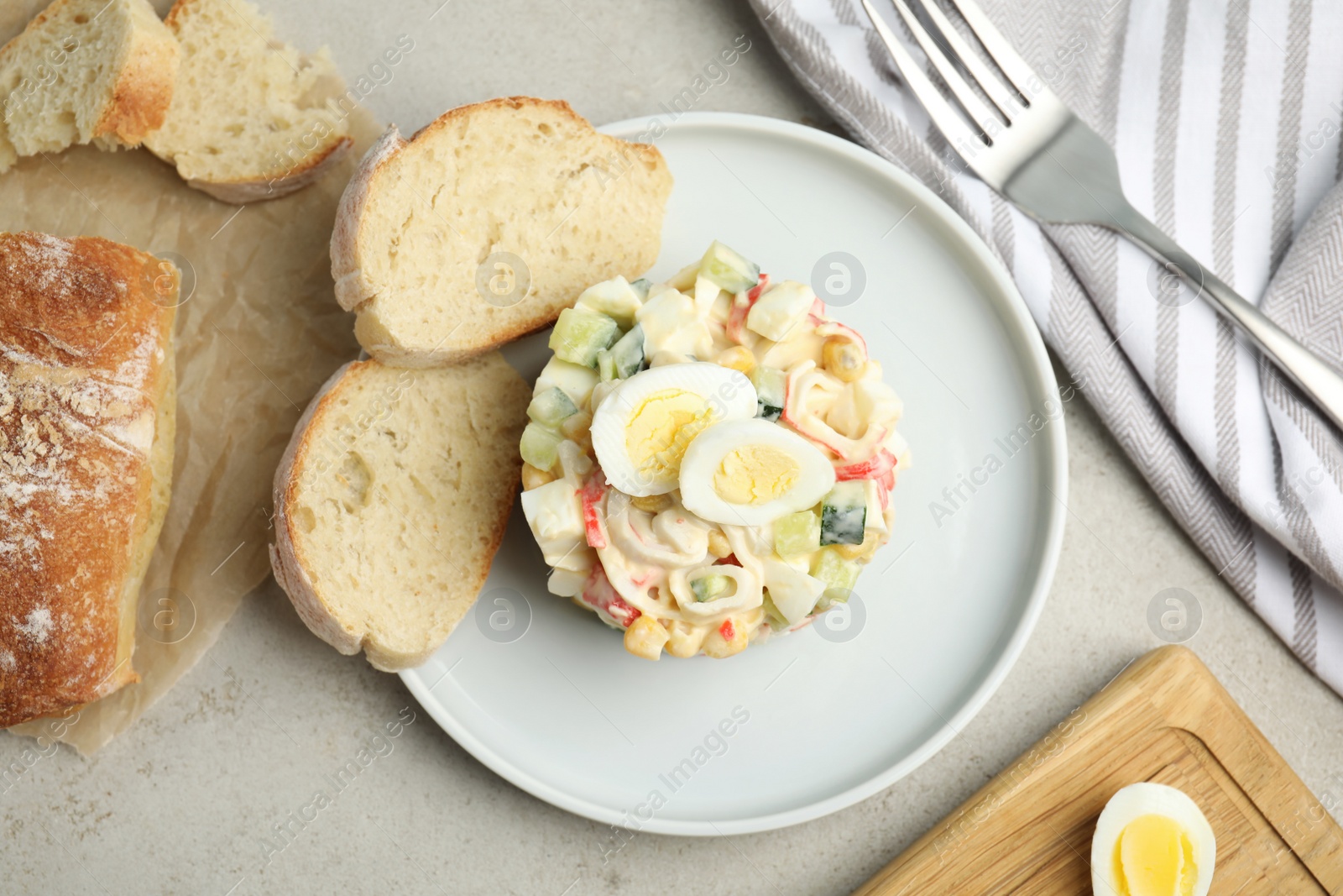 Photo of Delicious salad with crab sticks and eggs served on table, flat lay