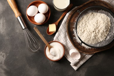 Photo of Different ingredients for dough on grey textured table, flat lay