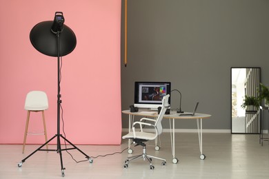 Photo of Pink photo background, workplace and professional lighting equipment in modern studio