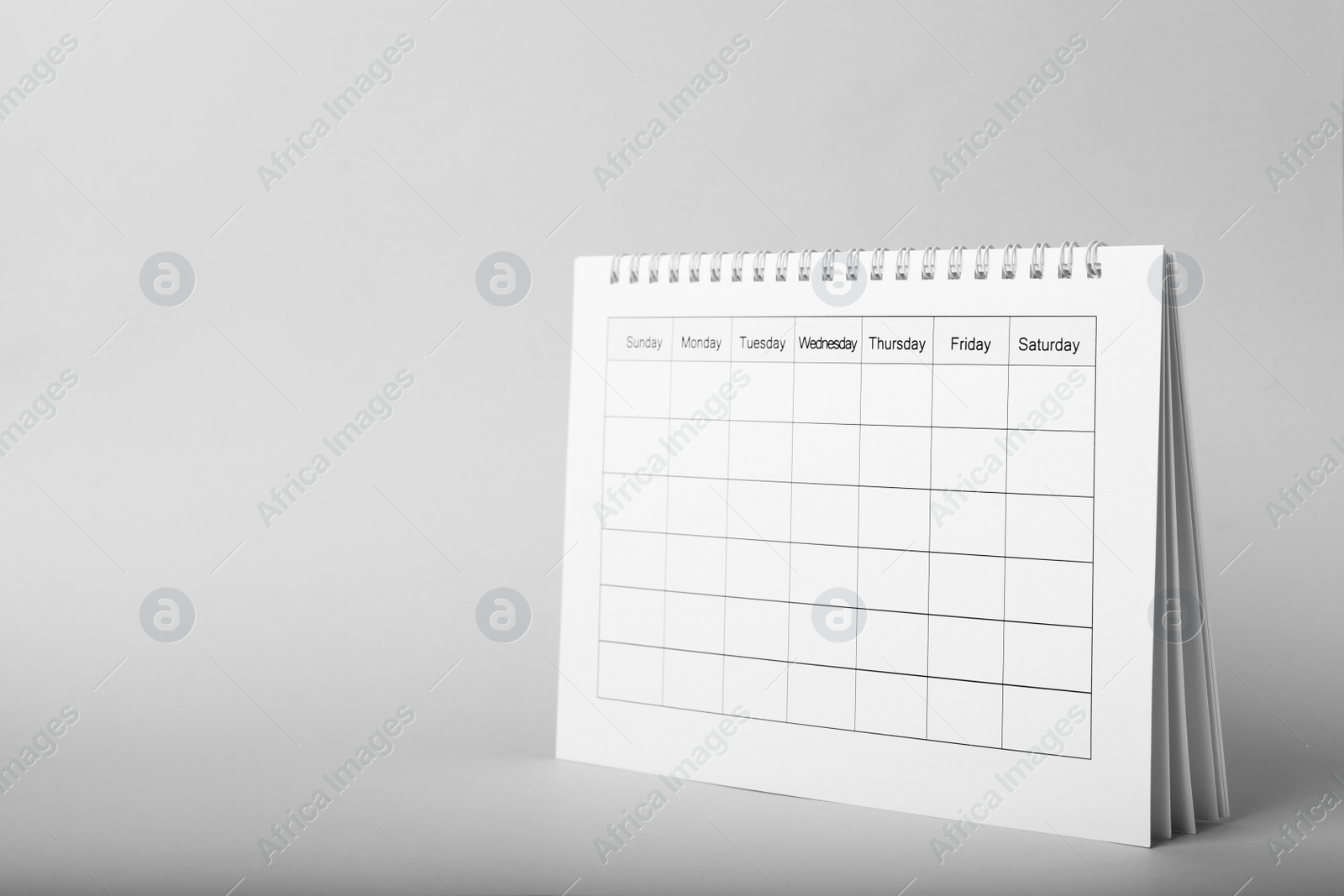Photo of Blank paper calendar on grey background, space for text. Planning concept