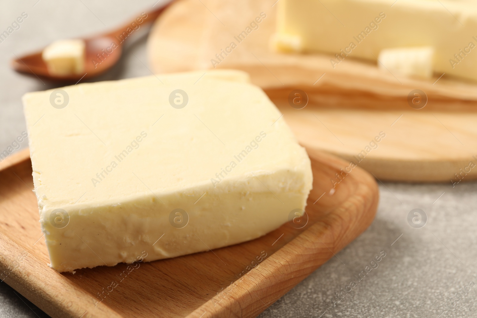 Photo of Block of tasty butter on grey table, closeup