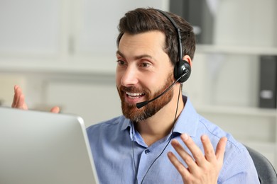 Photo of Emotional hotline operator with headset working in office
