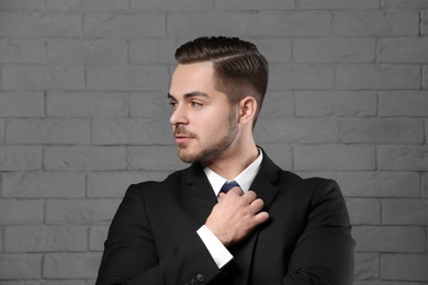 Portrait of young man with beautiful hair on brick wall background