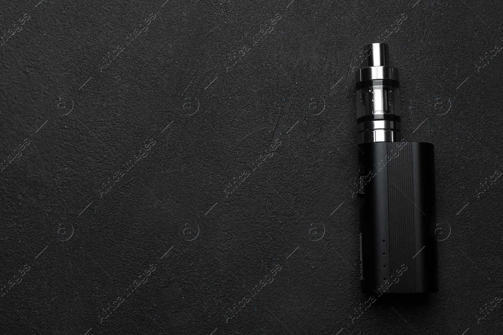 Photo of Electronic cigarette on black table, top view with space for text. Smoking alternative