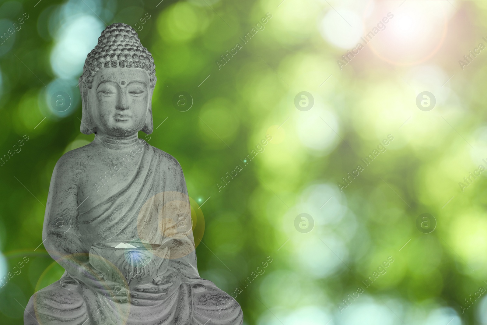 Image of Stone Buddha sculpture outdoors. Space for text