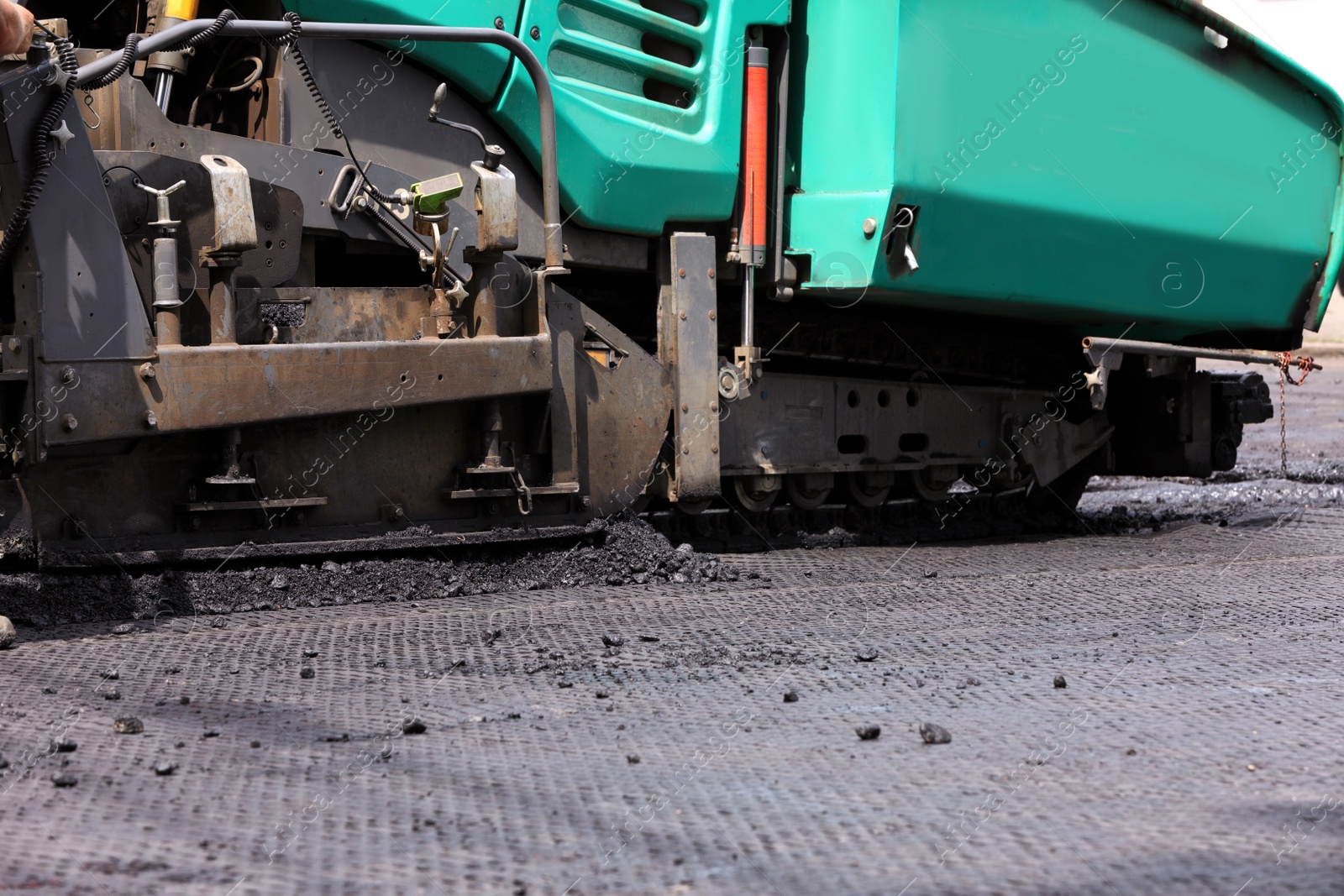 Photo of Asphalt paver working on street, closeup. Road repair