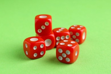 Photo of Many red game dices on green background, closeup