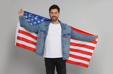 Photo of 4th of July - Independence Day of USA. Happy man with American flag on grey background