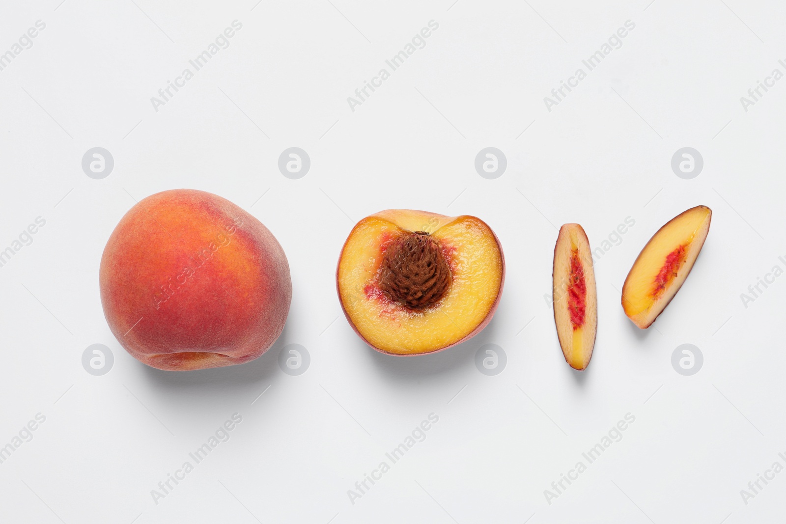 Photo of Cut and whole fresh ripe peaches on white background, flat lay