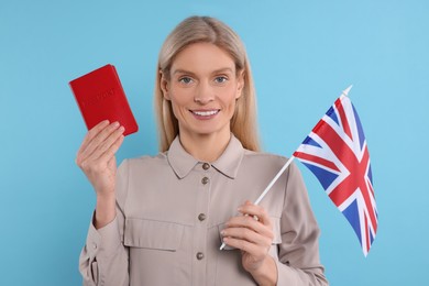 Immigration. Happy woman with passport and flag of United Kingdom on light blue background