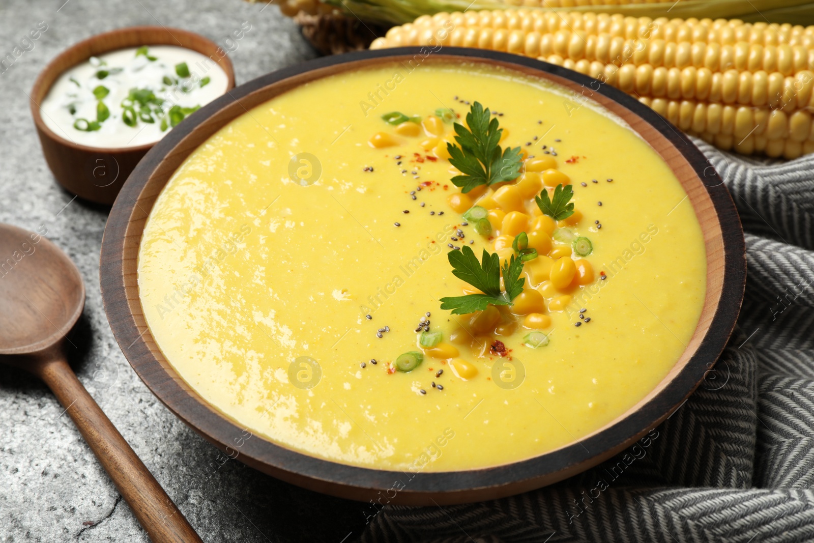 Photo of Delicious creamy corn soup served on grey table