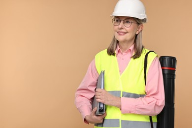 Architect in hard hat with folder and tube on beige background, space for text