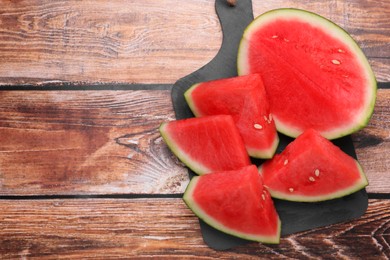 Juicy ripe cut watermelons on wooden table, top view. Space for text