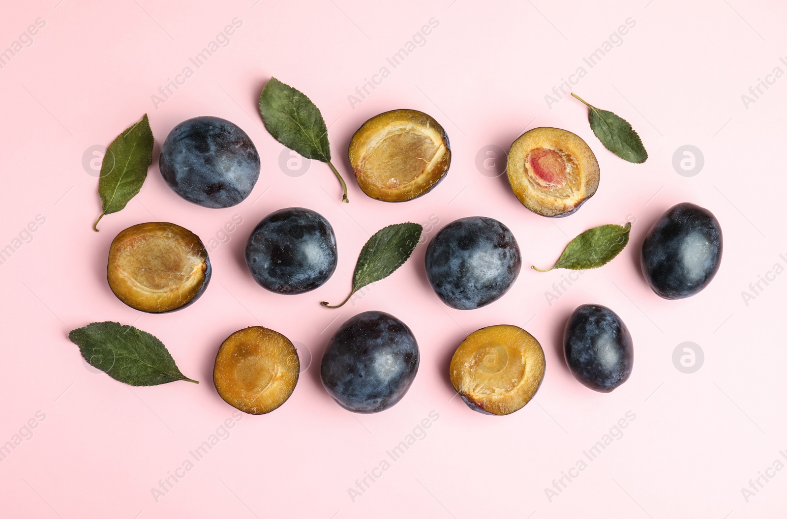 Photo of Delicious ripe plums on pink background, flat lay