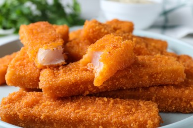 Photo of Fresh breaded fish fingers on plate, closeup