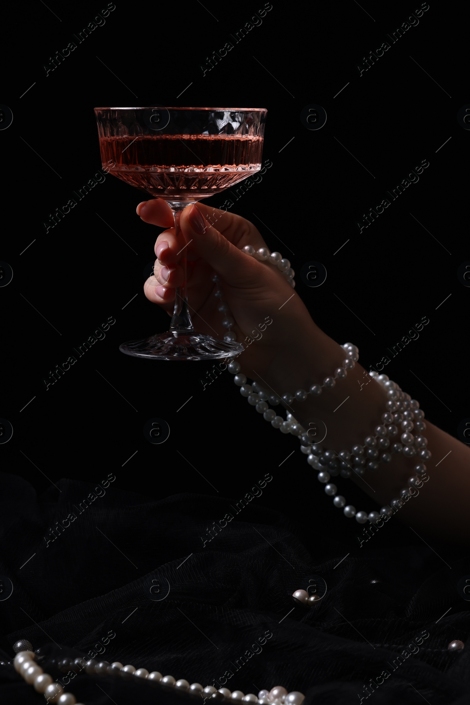 Photo of Fashionable photo of woman with glass of delicious wine against black background, closeup