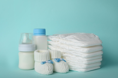 Photo of Diapers and baby accessories on light blue background