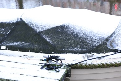 Moored boat covered with snow on winter day