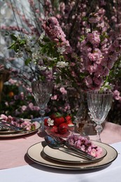 Photo of Stylish table setting with beautiful spring flowers in garden
