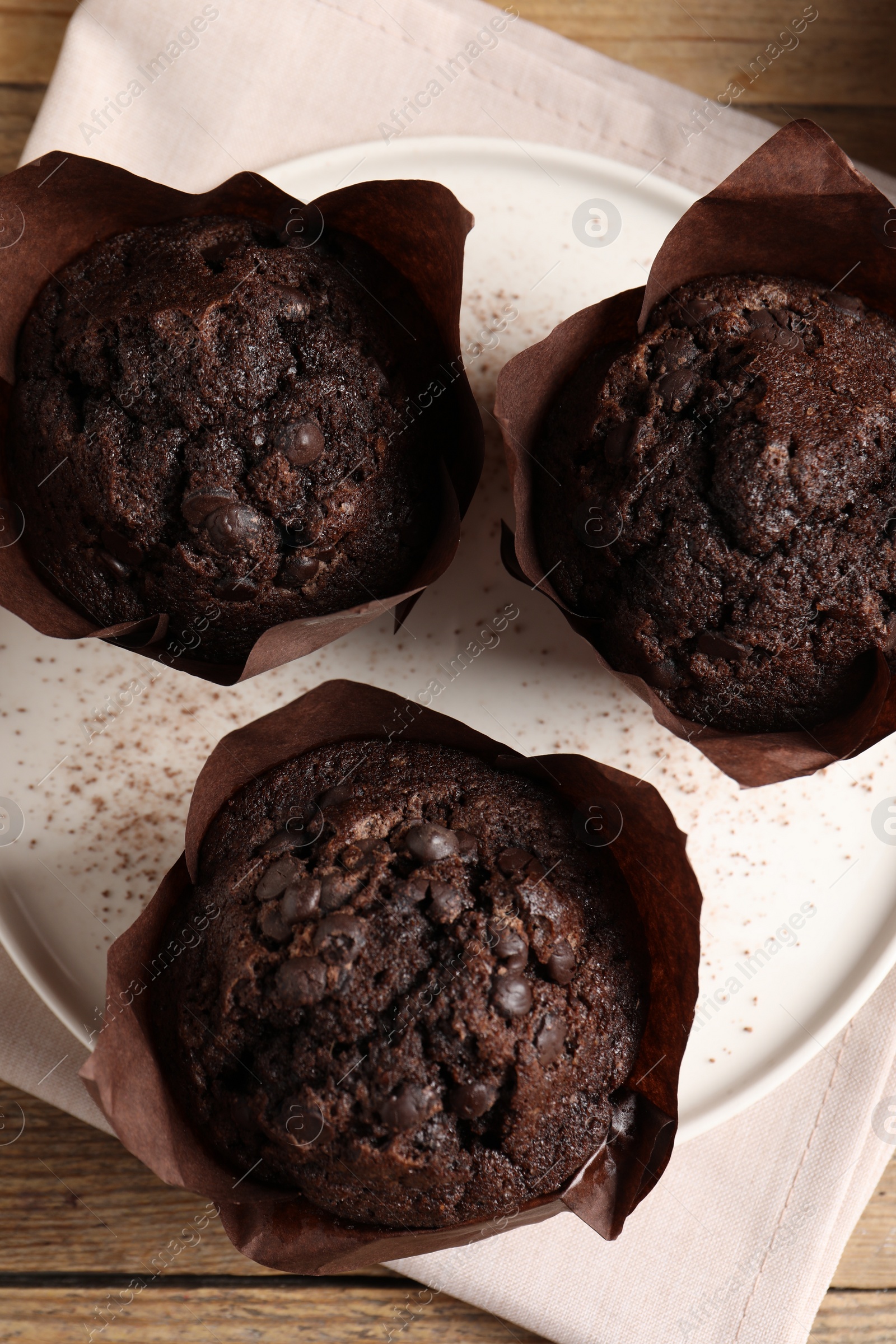 Photo of Tasty chocolate muffins on wooden table, top view