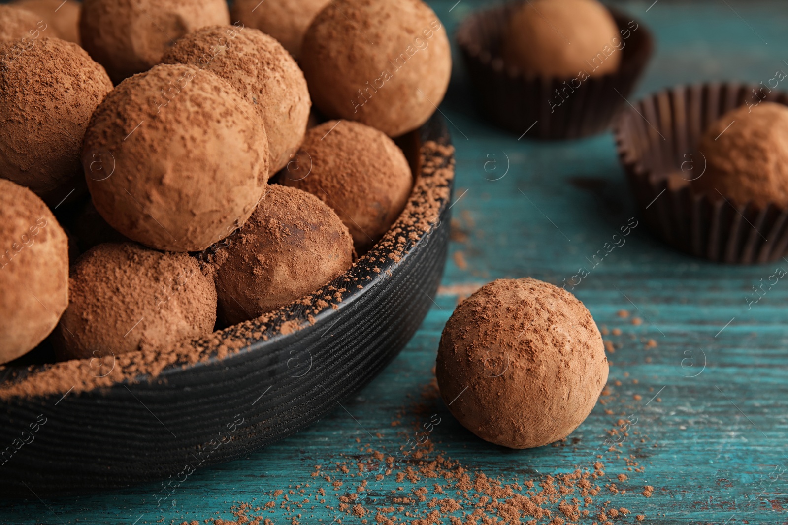 Photo of Plate of chocolate truffles on wooden background, closeup