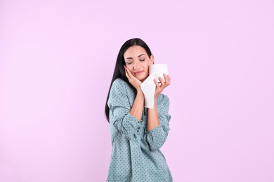 Photo of Beautiful woman holding toilet paper roll on color background