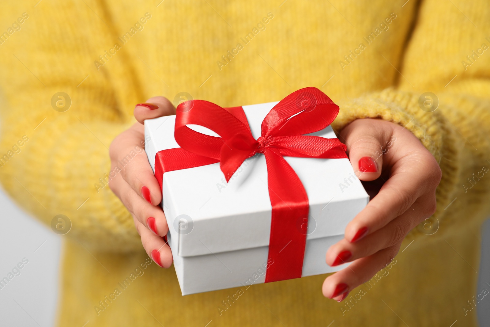 Photo of Christmas present. Woman holding gift box, closeup