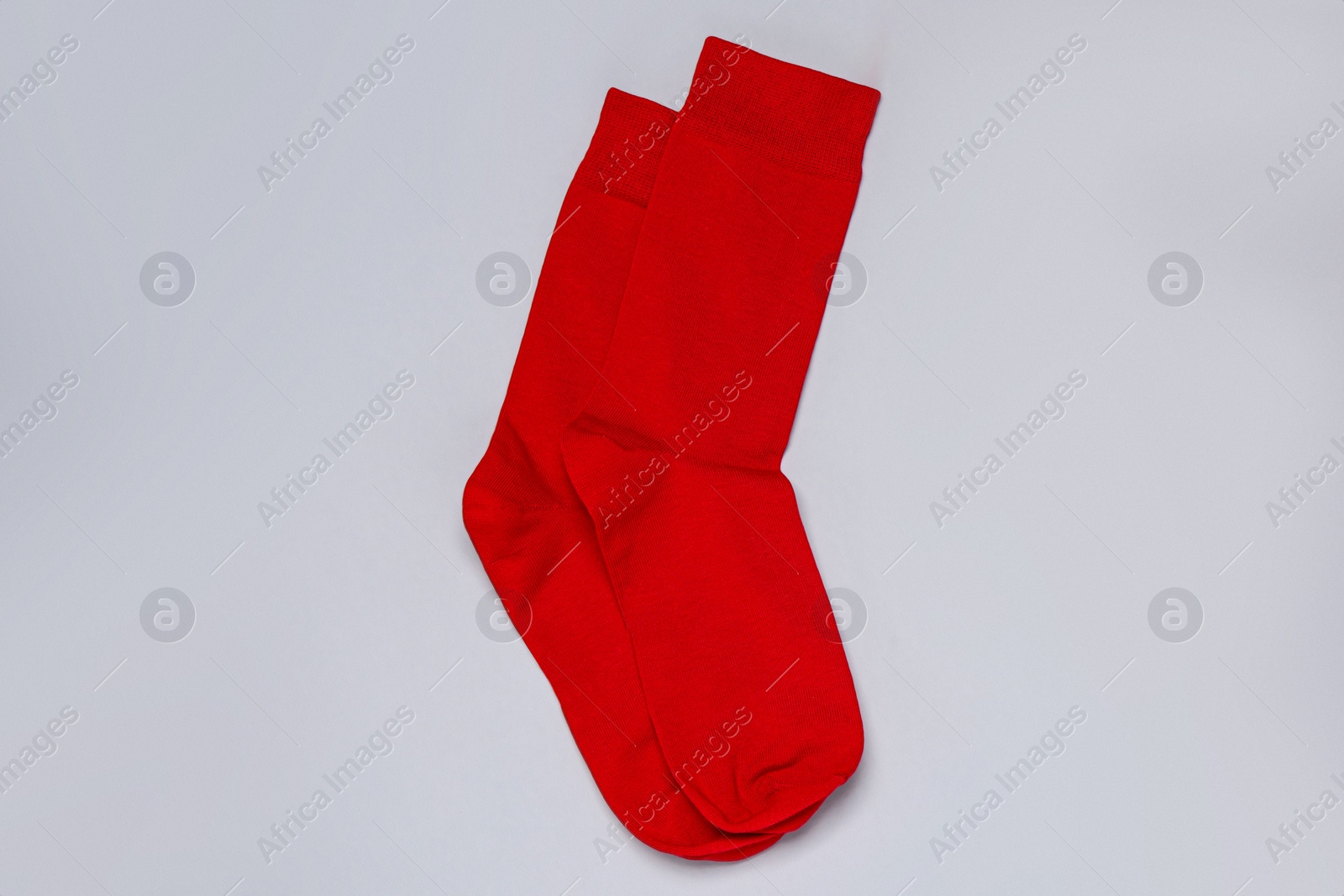 Photo of Pair of red socks on light grey background, flat lay