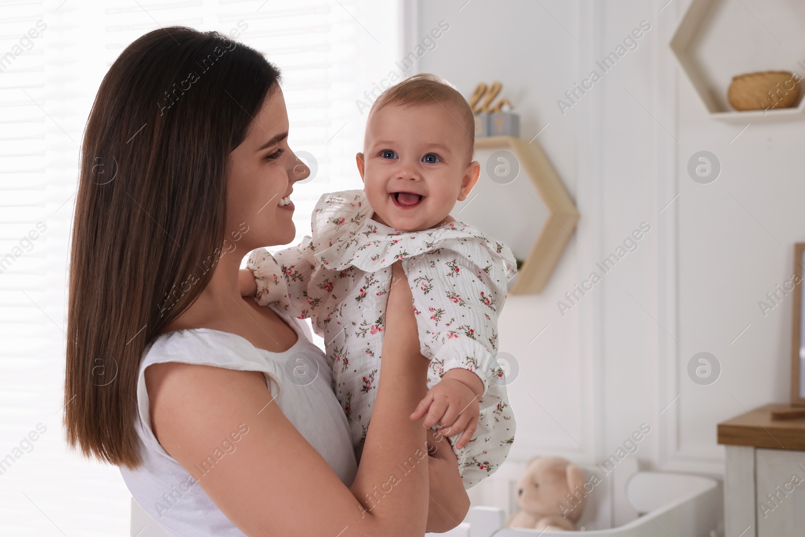 Photo of Happy young mother with her baby daughter at home