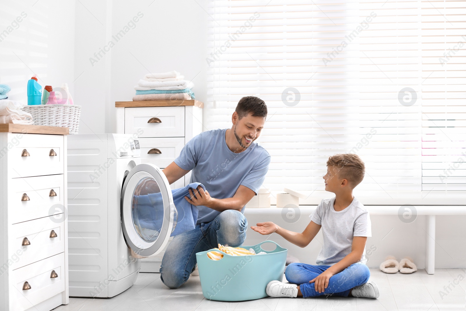 Photo of Dad and son doing laundry at home