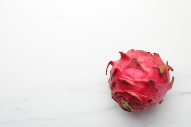 Delicious red pitahaya fruit on white marble table, top view. Space for text
