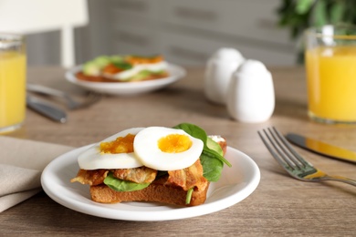 Photo of Sandwich with egg, bacon and spinach served on wooden table