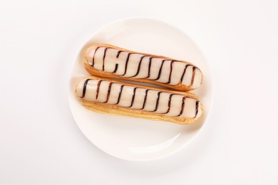 Photo of Delicious eclairs covered with glaze on white background, top view